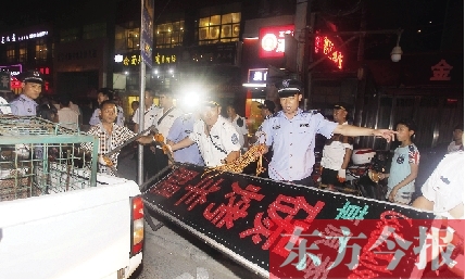 7月8日晚，鄭州市商城路一家占道經(jīng)營的攤販招牌被執(zhí)法隊員“登記保存”