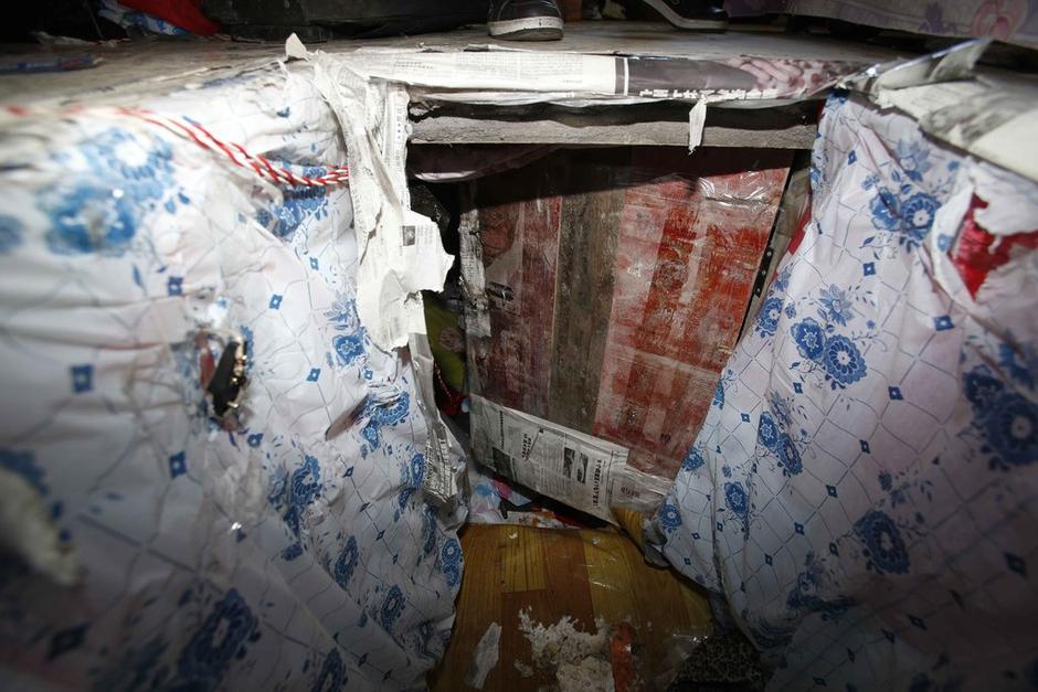 陳小龍在出租屋外，自行又圍起一堵圍墻，安裝了一個門。圍墻上都是豎起的鐵釘，外面堆著土，鄰居猜是從地底挖出來的。洞口就在床邊，0.5米見方，深約1.5米。洞口表面一塊紙板掩蓋，打開紙板跳入洞底，是一扇小木門，木門外有插銷，可以從外面鎖上。