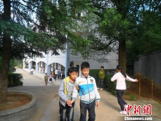 4年來(lái)，13歲的余興泉（左一）每天都攙扶著腿腳不便的同學(xué)左臣進(jìn)出教室、食堂和廁所。 李俊杰 攝