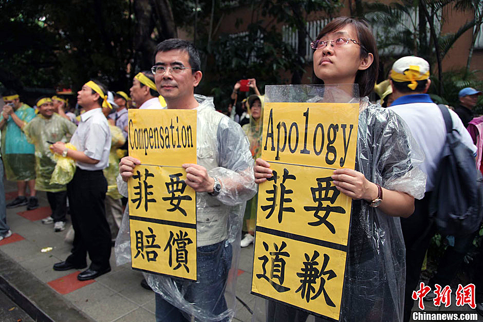 　圖為當(dāng)天下午，當(dāng)臺(tái)灣數(shù)百漁民在馬尼拉經(jīng)濟(jì)文化辦事處前抗議時(shí)，有兩名年輕人手持標(biāo)語(yǔ)，在路邊聲援。中新