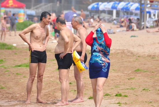 2013年7月3日，山東青島青島高溫來襲，“青島大媽”不懼滸苔，戴著“強盜面具”出現(xiàn)在海水浴場消暑降