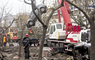 輸油管道爆炸后，搶修人員將被炸毀的車輛運(yùn)出現(xiàn)場(chǎng)。