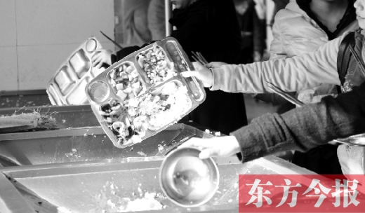 11月27日，河南中醫(yī)學(xué)院餐廳，一名同學(xué)將餐盤內(nèi)沒吃完的食物倒入餐具回收車內(nèi)