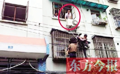施救現(xiàn)場，劉鵬（圈內(nèi)）先用繩子捆住老太確保安全 勞動報記者 郭娜 供圖