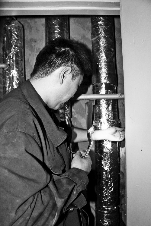 苗師傅一邊進(jìn)行維修，一邊用耳機(jī)接聽市民的電話。