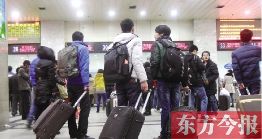 鄭州火車站東廣場(chǎng)售票大廳，幾名學(xué)生在售票窗口前躊躇