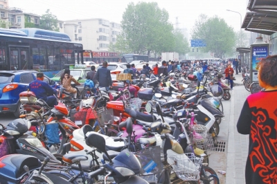 省人民醫(yī)院北門(mén)，路邊的公交站牌處停滿非機(jī)動(dòng)車，上、下客只能在快車道上。