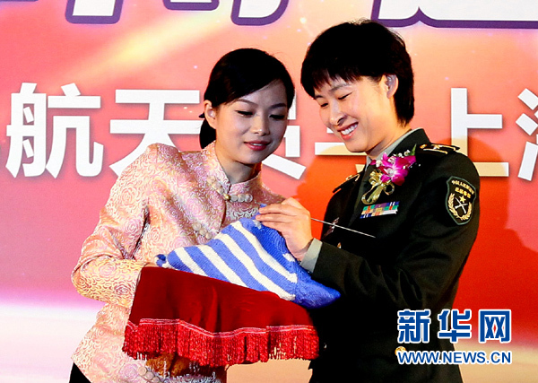 11月1日，航天員劉洋（右）在為“愛心”毛衣編織最后的收尾針。