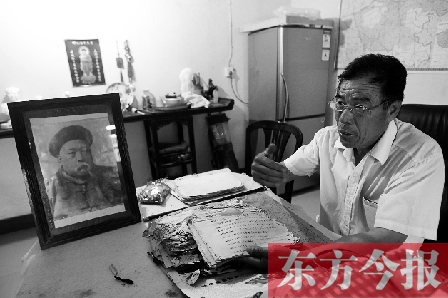 　魏樹紹手拿《物權(quán)法講義》手稿，在講訴先祖書寫“物權(quán)法”的歷史（相框里就是魏聯(lián)奎）