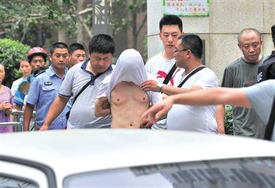 昨日，成都警方抓捕時(shí)與毒犯發(fā)生槍戰(zhàn)。一名男犯罪嫌疑人被警方押出。