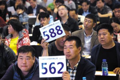 昨日，拍賣現(xiàn)場競拍者舉牌競拍。新京報記者