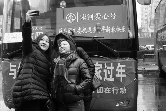 昨天上午8時(shí)，鄭州正道中環(huán)百貨廣場，準(zhǔn)備回家的老鄉(xiāng)在愛心大巴車前合影留念