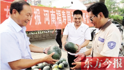 河南福壽園區(qū)域總經(jīng)理吳正宗（左一）、東方今報(bào)發(fā)行中心副總監(jiān)王路喜（中）在街頭給市民送瓜