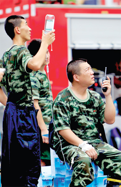 火場(chǎng)外，被消防戰(zhàn)士稱(chēng)為“李大隊(duì)”的救援人員掛著吊瓶現(xiàn)場(chǎng)指揮