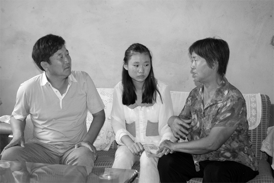 “商丘最美女兒”李丹（中）捐骨髓救母，愛(ài)心人士（左）送來(lái)1萬(wàn)元愛(ài)心款