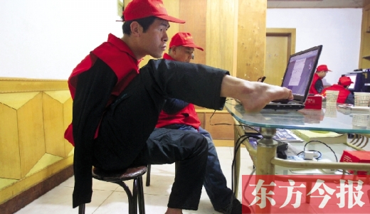 12月2日，一名“豫殘聯(lián)盟”志愿者正通過網(wǎng)絡(luò)、微博等聯(lián)絡(luò)著各地殘疾人朋友 東方今報首席記者 張曉冬