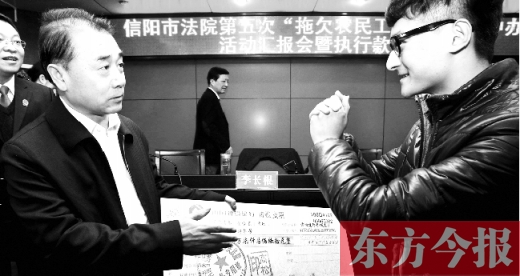 張立勇將依法執(zhí)行回來的農(nóng)民工工資發(fā)放給案件當事人游昌華，游昌華施以中國傳統(tǒng)作揖禮答謝