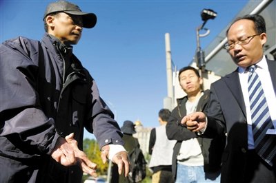 常林鋒在法院外展示雙手，他稱被燙傷的手因刑訊逼供且未得到及時救治