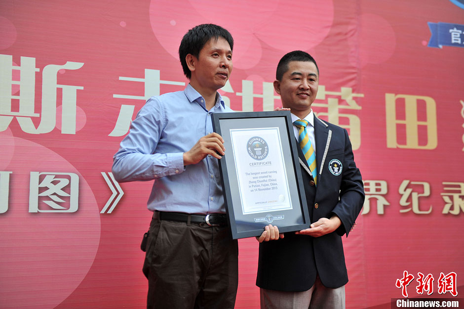 圖為世界吉尼斯認(rèn)證官為鄭春輝（左）頒發(fā)證書。呂明 攝