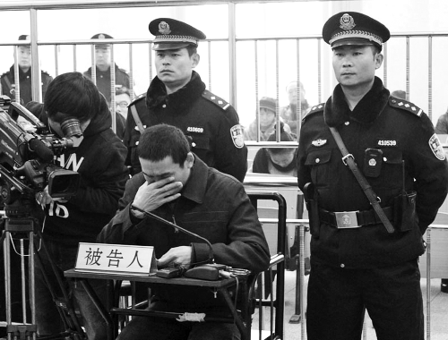 庭審中,29歲的李軍低著頭。