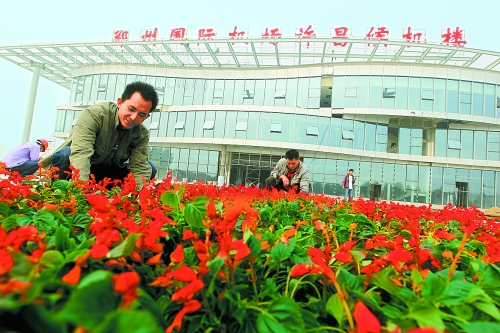 9月23日，工人們正在鄭州國際機場許昌候機樓前擺放鮮花。