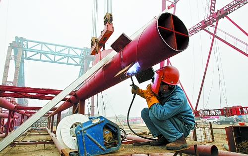 2月25日，在跨越南水北調(diào)總干渠的鄭州新鄭南段十里鋪公路橋施工現(xiàn)場，建設(shè)者在緊張地施工。