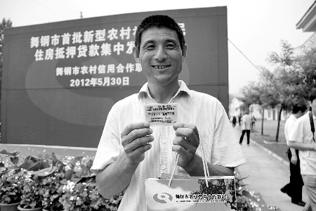 領(lǐng)到貸款，農(nóng)民開(kāi)心地笑了。