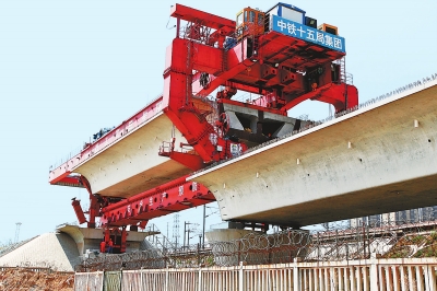 建設(shè)者們操縱巨型起重機(jī)在吊放橋墩。記者鄧放攝