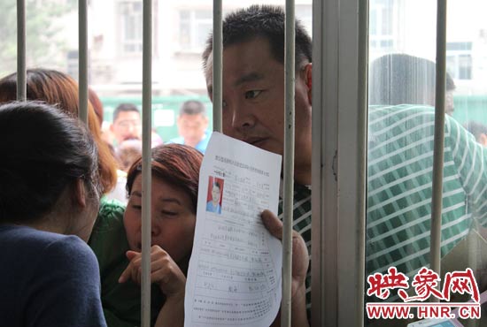 不少家長擠在報名窗口前咨詢報名事宜。