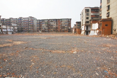 為降塵，旮旯王村拆遷后裸露的地面上鋪了一層石子。