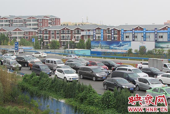 記者看到鄭州機場收費站口車輛排隊，與此形成鮮明對比的是，路的對面（另一半幅）卻車輛較少，通行順暢。