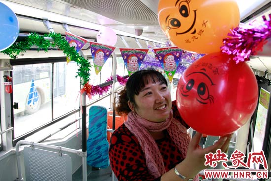 鄭州快速公交B3區(qū)間線車長李鵬云在車廂里懸掛氣球，布置圣誕車廂，營造歡樂圣誕氛圍