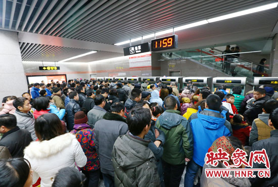 地鐵開通首日，上午十一點五十九分，紫荊山地鐵站售票機前擠滿了買票的市民。