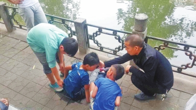 男孩被救出后，圍觀群眾幫他控水換衣服。