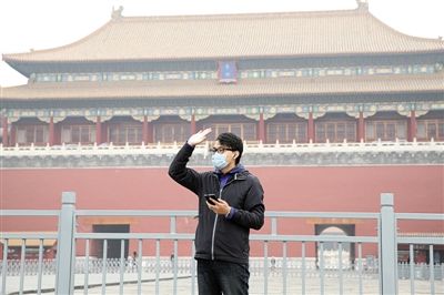 11月1日，北京大部分地區(qū)重度污染，一名游客戴著口罩在午門(mén)前揮手跟朋友打招呼。 實(shí)習(xí)生 王飛 攝