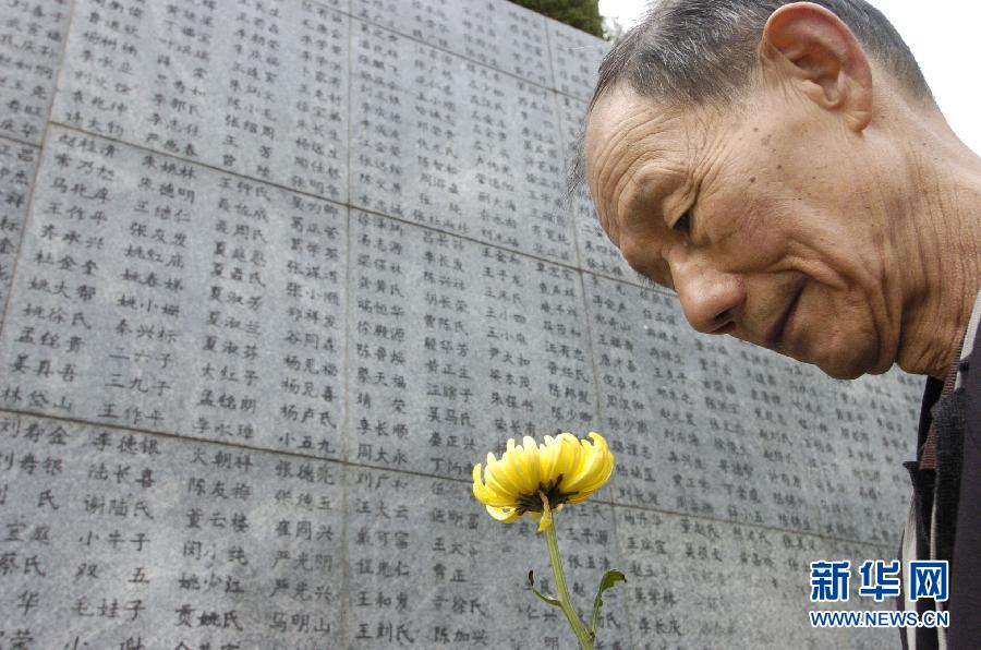2006年4月5日，74歲的南京大屠殺幸存者佘子清手捧鮮花，祭奠被日軍殺害的母親。
