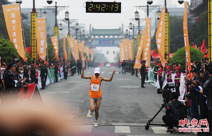 一名選手抵達終點后，高舉雙手慶祝。