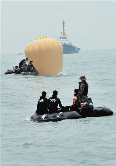 18日，搜救人員準備將氣囊捆綁到沉沒客輪上。