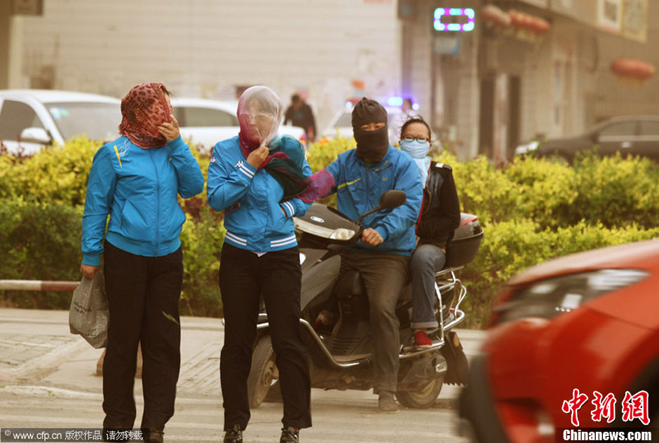 2014年04月23日，新疆維吾爾自治區(qū)吐魯番地區(qū)，市民戴著口罩行走在大風沙塵中的吐魯番市街頭。