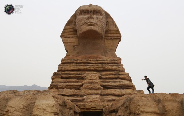 石家莊郊外，一名男子與山寨版獅身人面像合影留念。