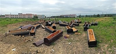 40多副棺木被砸壞后，扔在荒地上。