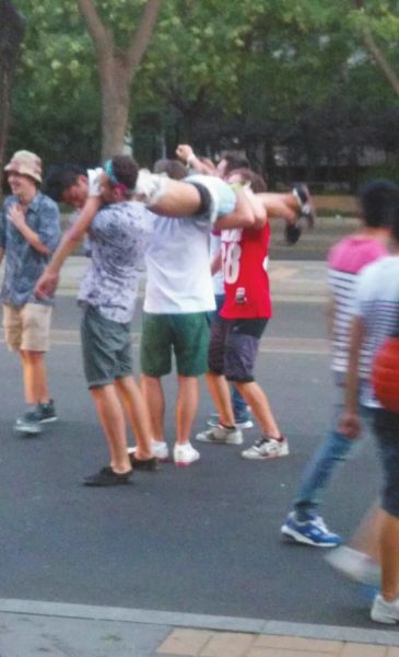 　四名外籍男子一同扛起醉漢拍照。