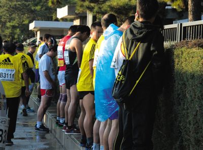 2013年10月20日，北京馬拉松比賽，由于廁位有限，一些選手在綠化帶“就地解決”。圖/IC