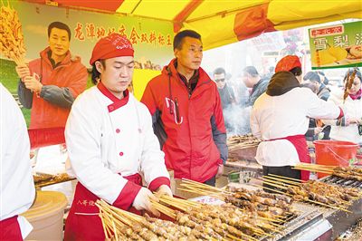 賣羊肉串?dāng)偽焕习遐w山（穿紅衣者）。新京報(bào)記者