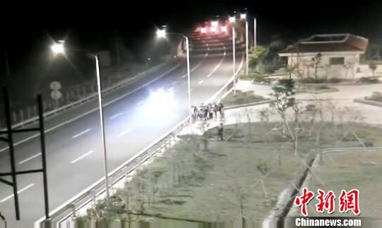 看到車輛經(jīng)過，孩子們便急忙跑到一旁的花圃上?！【焦﹫D　攝