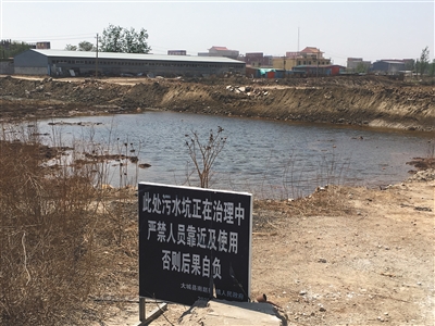 化肥廠滲坑的三分之一經(jīng)過治理，但水質(zhì)仍然呈黃褐色。