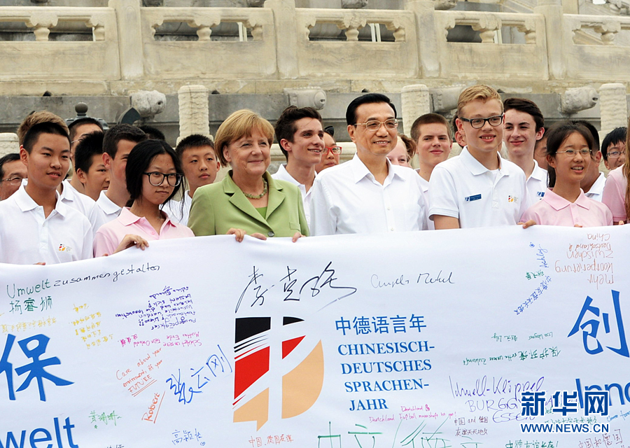 李克強同默克爾與青少年在天壇祈年殿前合影留念。