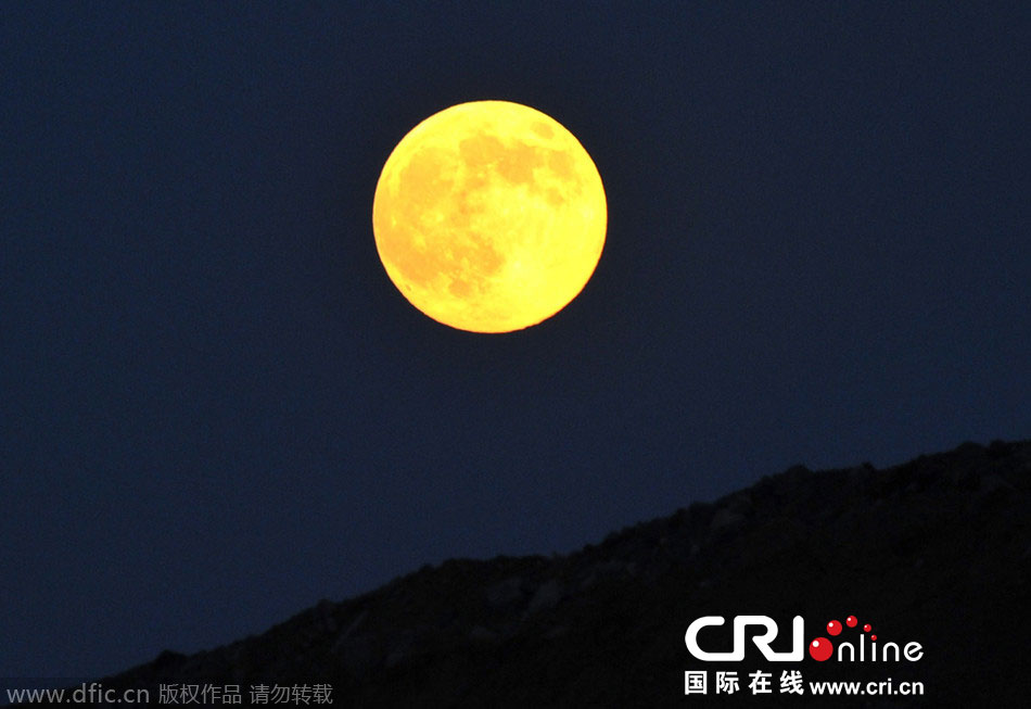 8月10日晚，一輪金燦燦的大月亮在遼寧省大連市東方升起。圖片來源：劉德斌/東方IC