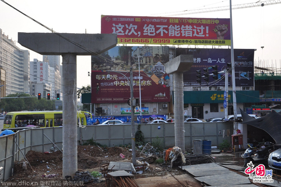 過(guò)街天橋一側(cè)的橋樁早已打好,可是對(duì)面的郵政銀行網(wǎng)點(diǎn)依舊在照常營(yíng)業(yè)。