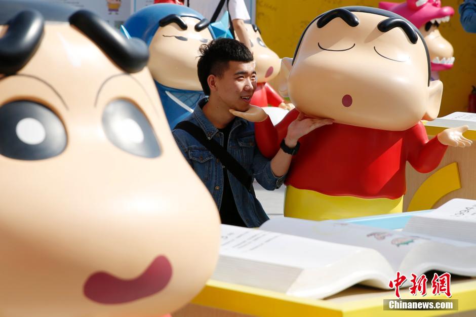 4月22日，游客與蠟筆小新合影?！跋灩P小新25周年紀念特展”日前在北京開展，吸引了不少市民游客。
